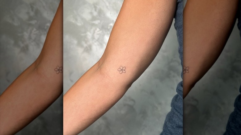 small tattoo of flower on arm