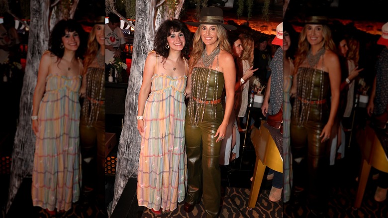 Lainey Wilson posing in a leather outfit with an oversized necklace