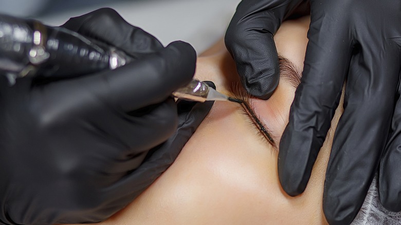 person getting lash enhancements tattoos