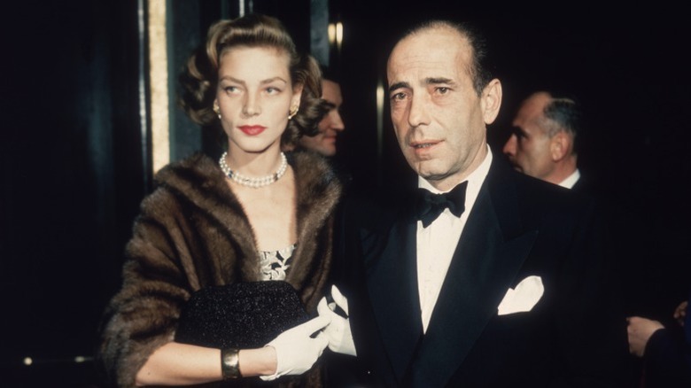 Lauren Bacall and Humphrey Bogart, dressed formally, arrive at an event
