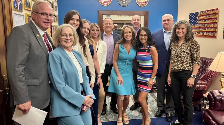Lauren Boebert wearing a tight multicolor dress while posing for a photo with the Colorado Home Builders Association