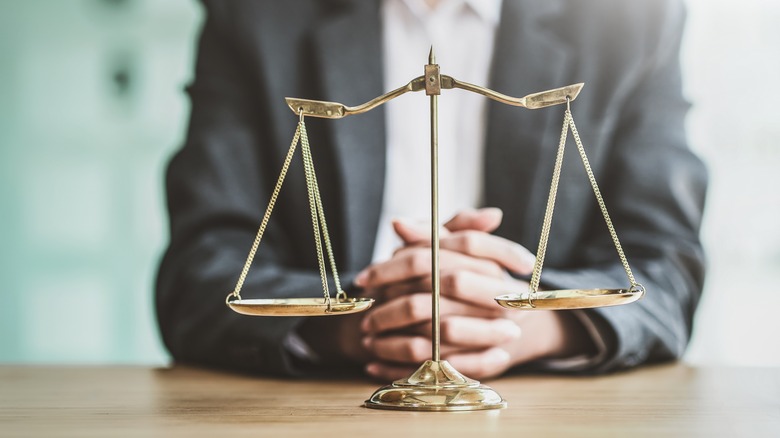 Person watching gold balancing scales