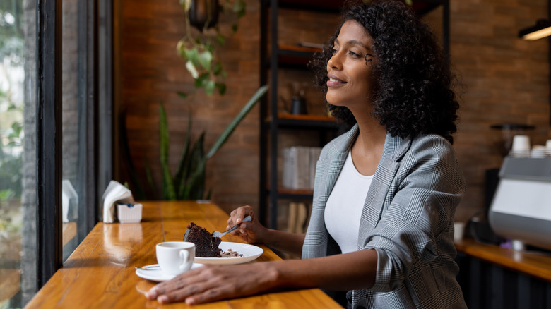 Happy woman enjoying cake in cafe