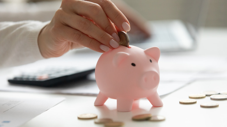 putting coin in piggy bank