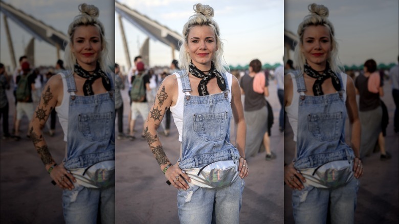 Manon wearing light-wash denim overalls