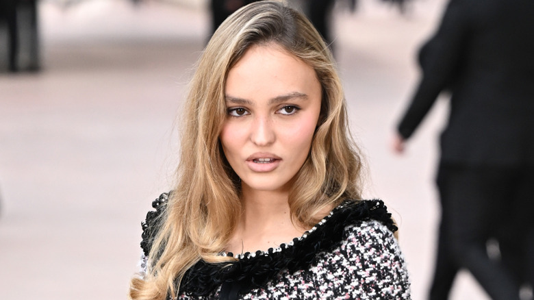Lily-Rose Depp posing in a tweed Chanel outfit