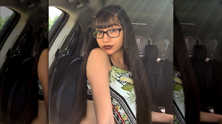 Woman in her car wearing lip gloss