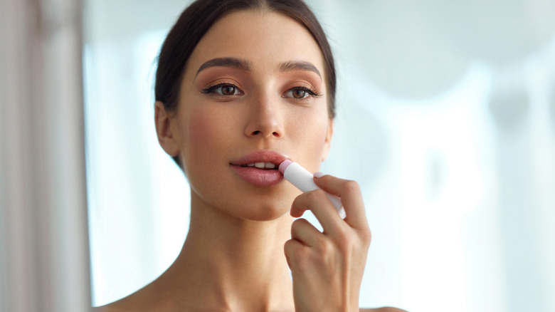 Woman applying lip balm/tint