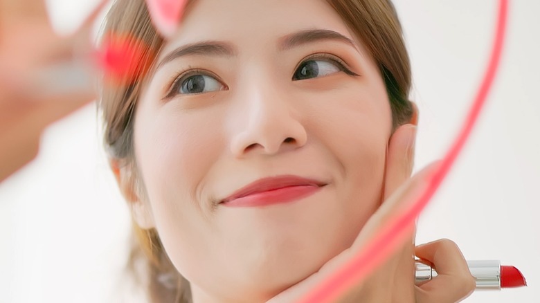 female using solid lipstick