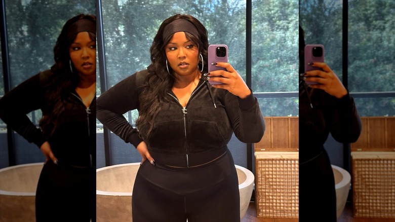 Lizzo posing in a selfie in a tracksuit and black headband