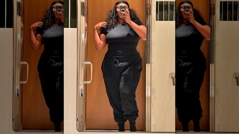 Lizzo taking a selfie in workout clothes.
