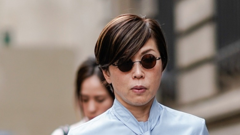 A woman with a side-swept fringe walks down the street