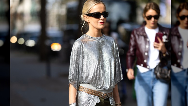 Woman wearing baggy silver shirt and belt