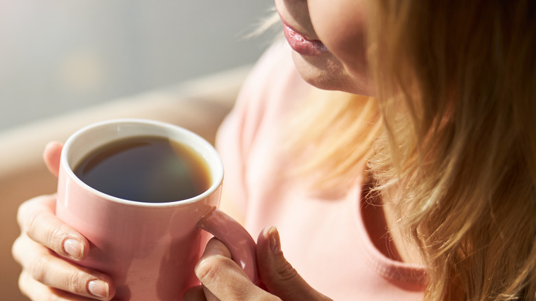 woman holding cup of coffee