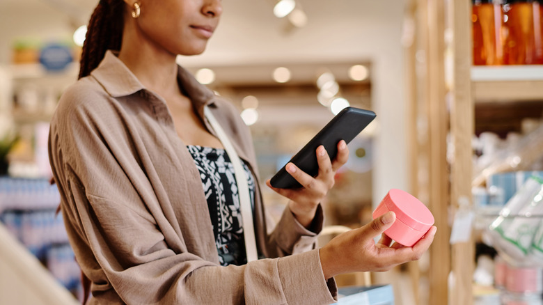 A woman analyzing a beauty product in a store
