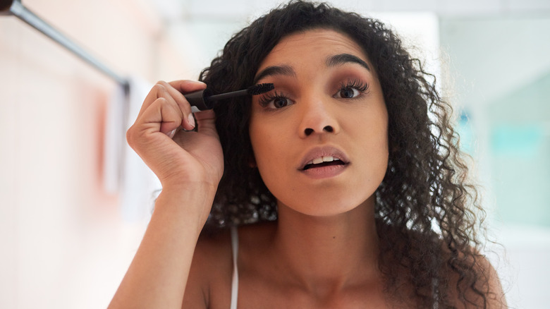 A woman applying mascara
