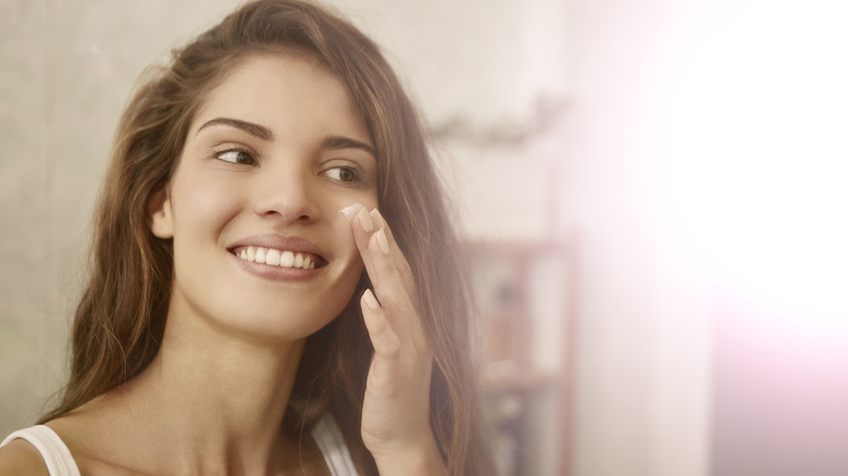 A woman applying moisturizer