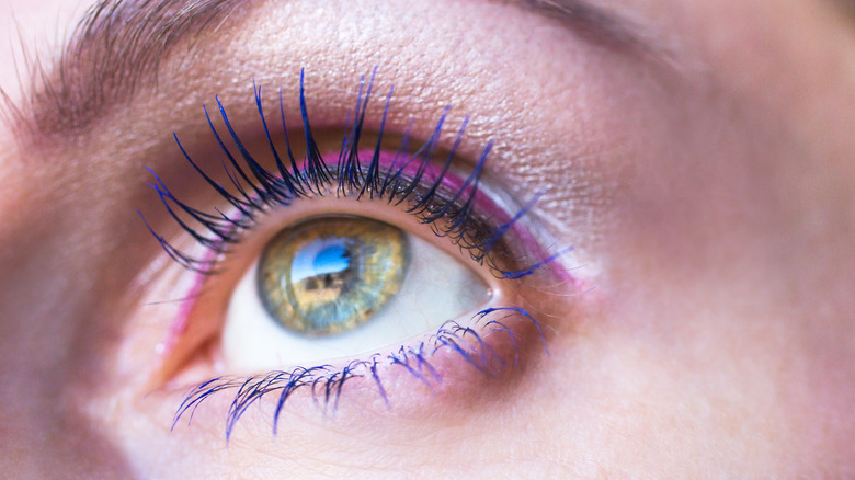 A woman wearing blue mascara on her eyelashes