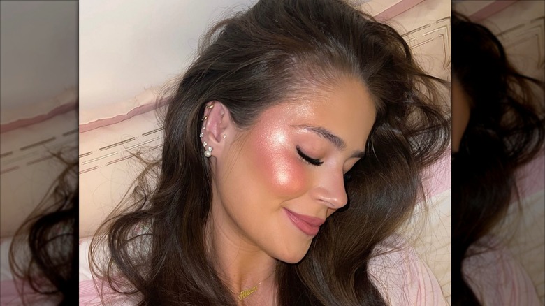 A woman wearing shimmery pink blush over sharp bronzer