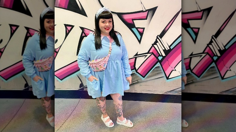 Girl wearing pink fanny pack with blue dress.