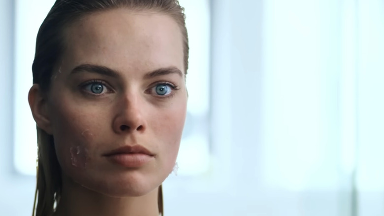 Margot Robbie without makeup looking into a mirror in a Vogue feature