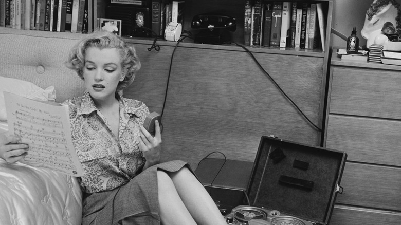 Marilyn Monroe looks at sheet music.