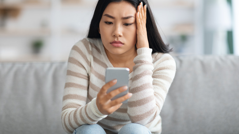 woman annoyed by text message