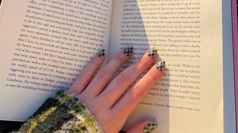 woman's hand on book