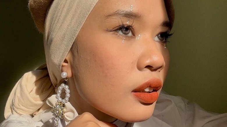 woman wearing matte makeup and gems around the eyes