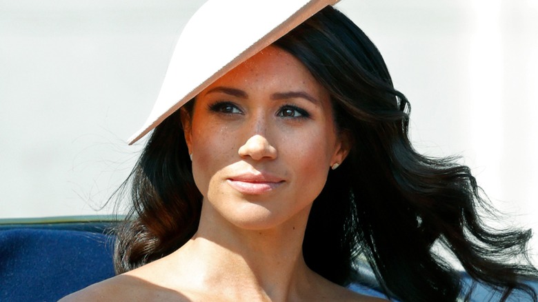 Close-up of Meghan Markle wearing a light pink disc-shaped fascinator