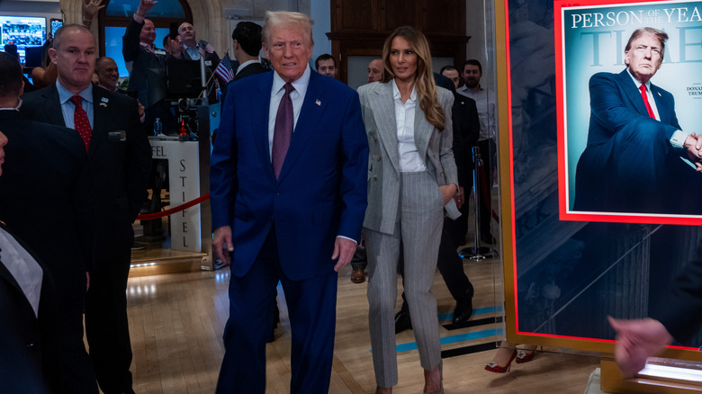 Melania Trump in a Ralph Lauren pantsuit walking behind Donald Trump