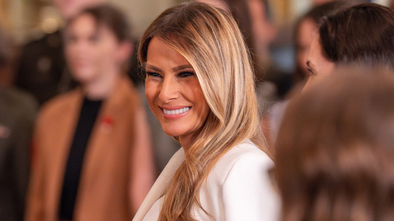 Melania Trump wearing white and smiling
