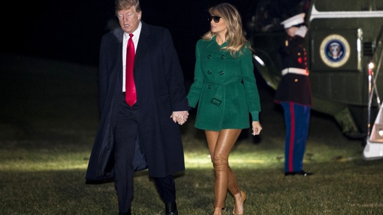 Donald and Melania Trump hold hands as they walk to the White House