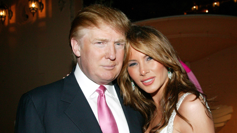 Donald Trump and Melania Trump look directly at the camera while lean in for a photo together