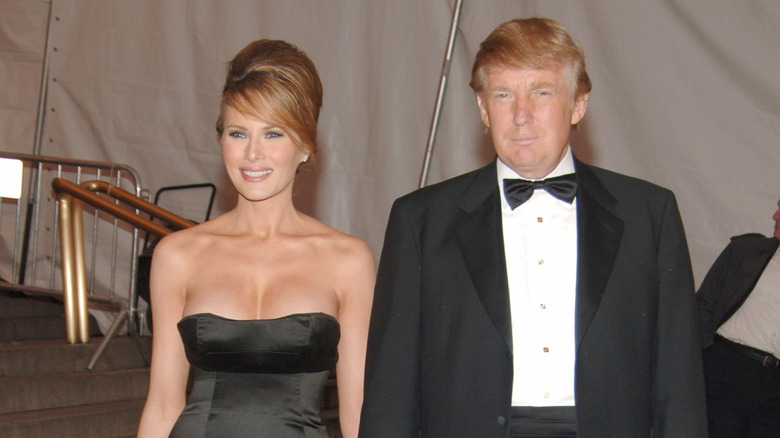 Melania and Donald Trump pose hand-in-hand wearing formal evening attire
