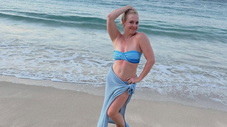 Melissa Joan Hart posing in a blue bikini on the beach.