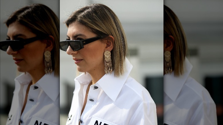 Woman wearing statement metallic earrings