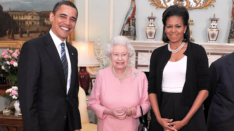 Barack Obama and Michelle Obama flank Queen Elizabeth while visiting Buckingham Palace