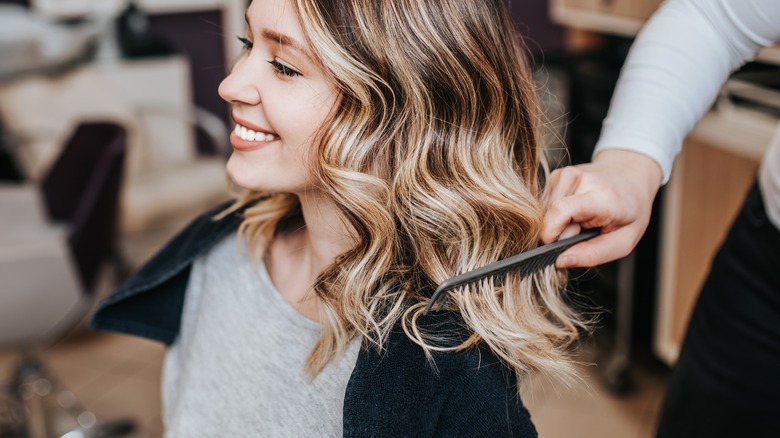 Woman getting hair done at salon 