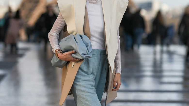 Woman holding light-blue clutch bag