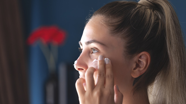 A woman applying skincare