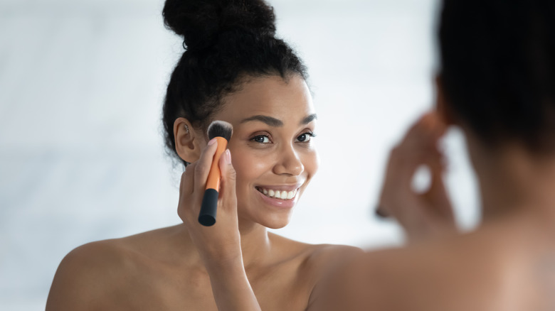 Woman blending makeup with brush