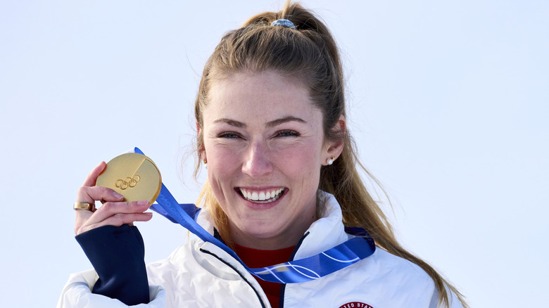 Mikaela Shiffrin smiles while showing her gold medal at the 2026 Olympic games