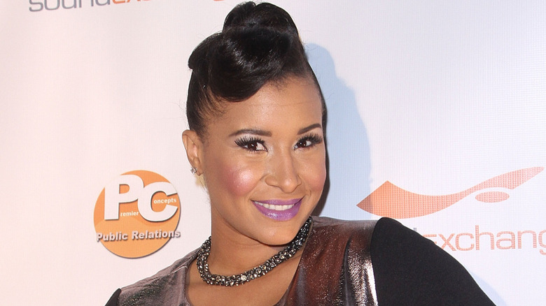 Mikki Bey posing and smiling during a red carpet event