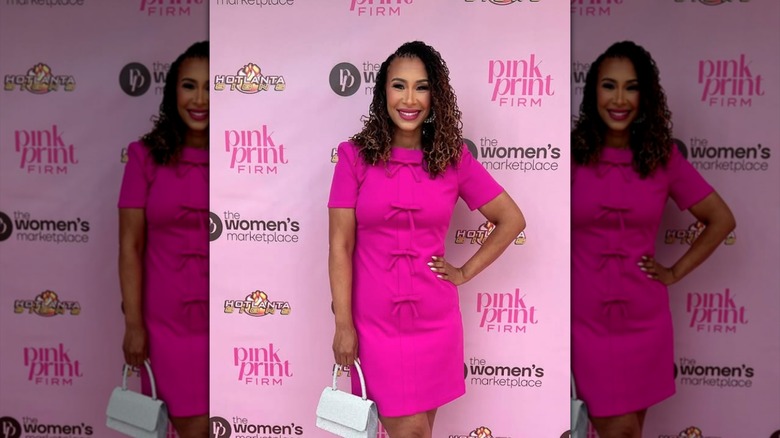 Mikki Bey posing in a pink dress with bows on it