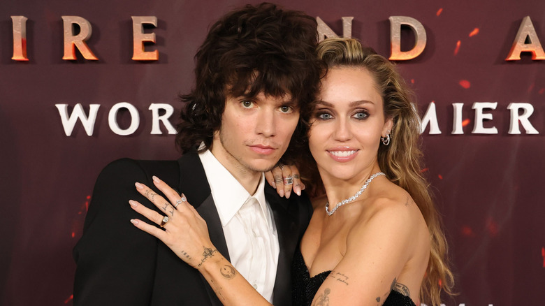 Maxx Morando and Miley Cyrus pose on the red carpet