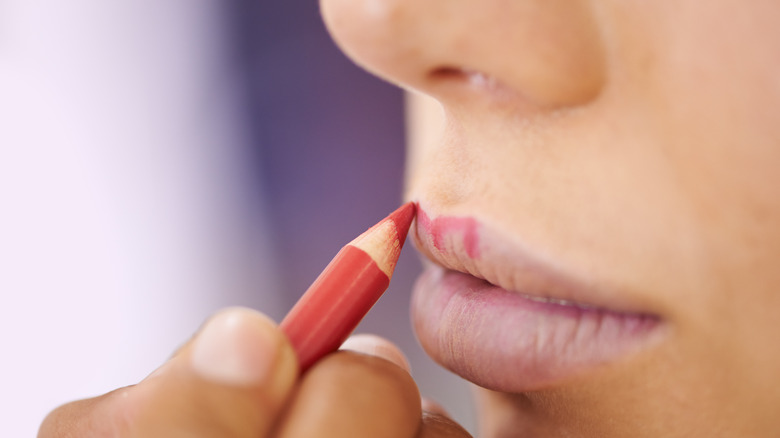 girl drawing lip liner