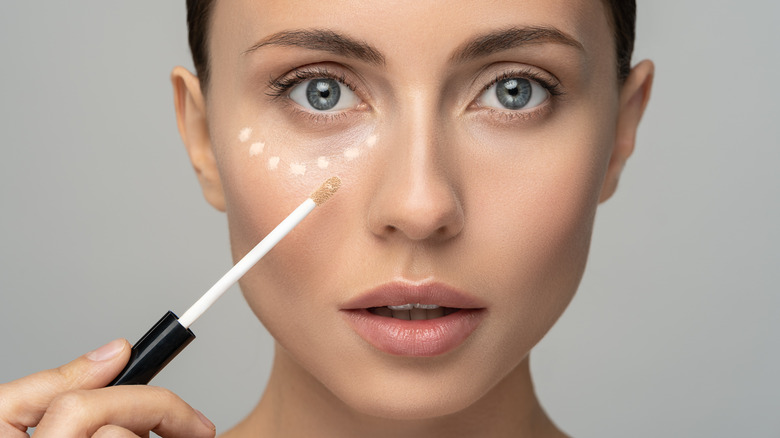 Woman applying concealer
