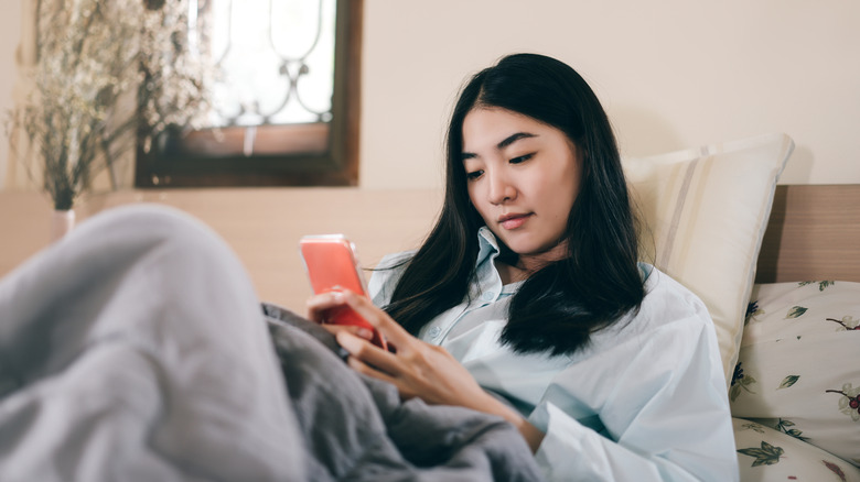 woman in bed with phone