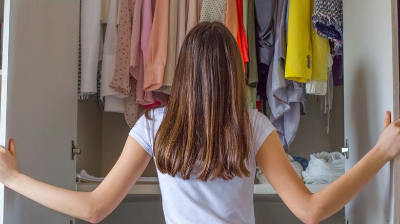 woman looking in clothes closet